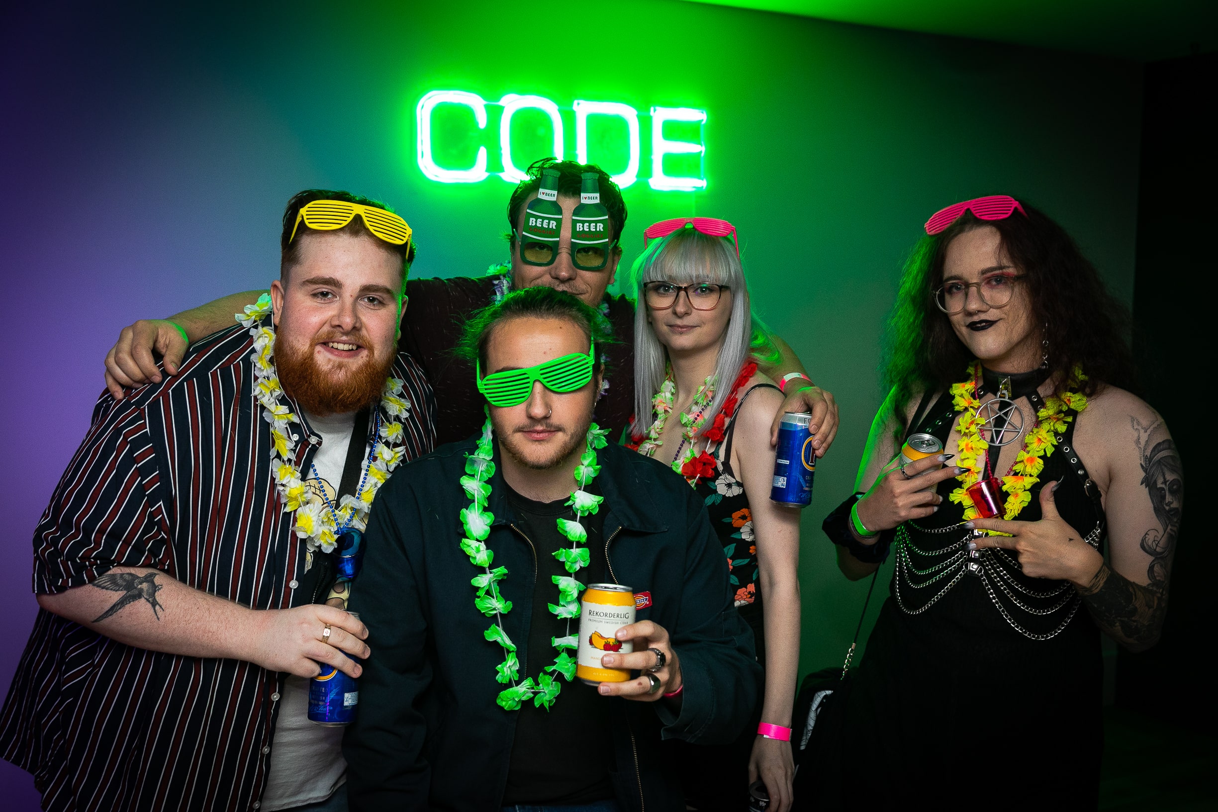 Group of students posing infront of neon CODE sign at CODE Leicester Welcome party