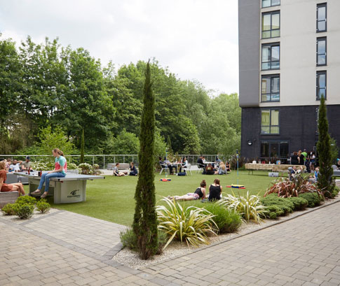 Students sitting on the grass outside the CODE Leicester halls