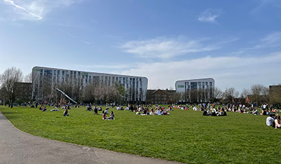 Bede Park, Leicester and the CODE accommodation building with students enjoying the sun.