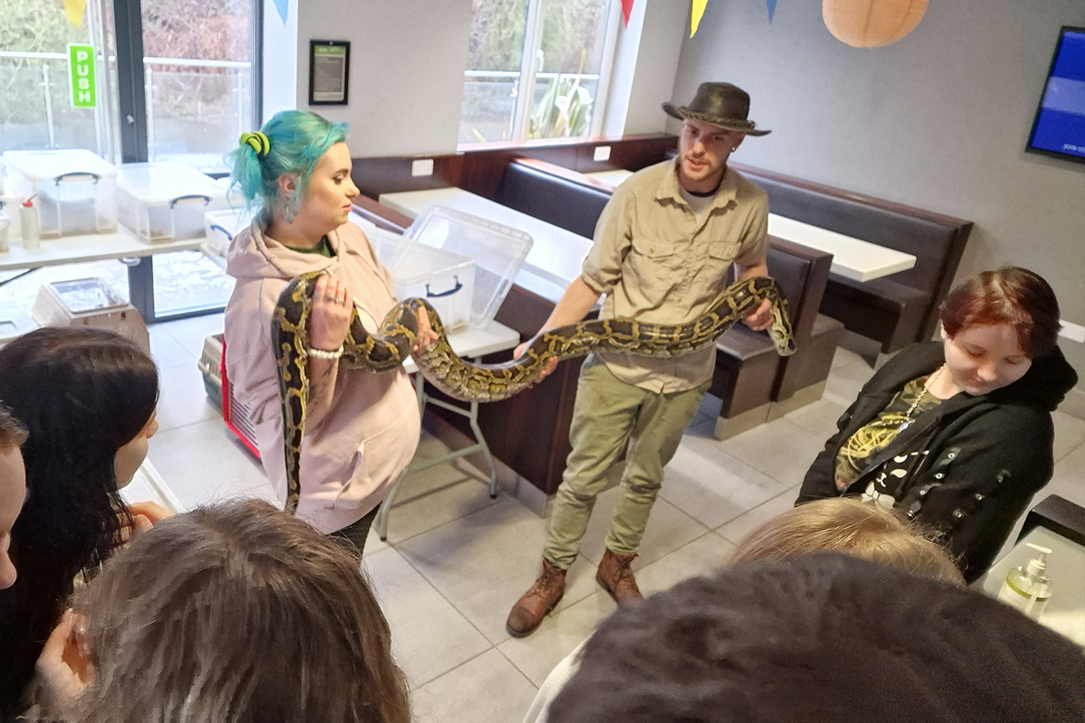CODE Student Accommodation Leicester Residents holding a snake with handler