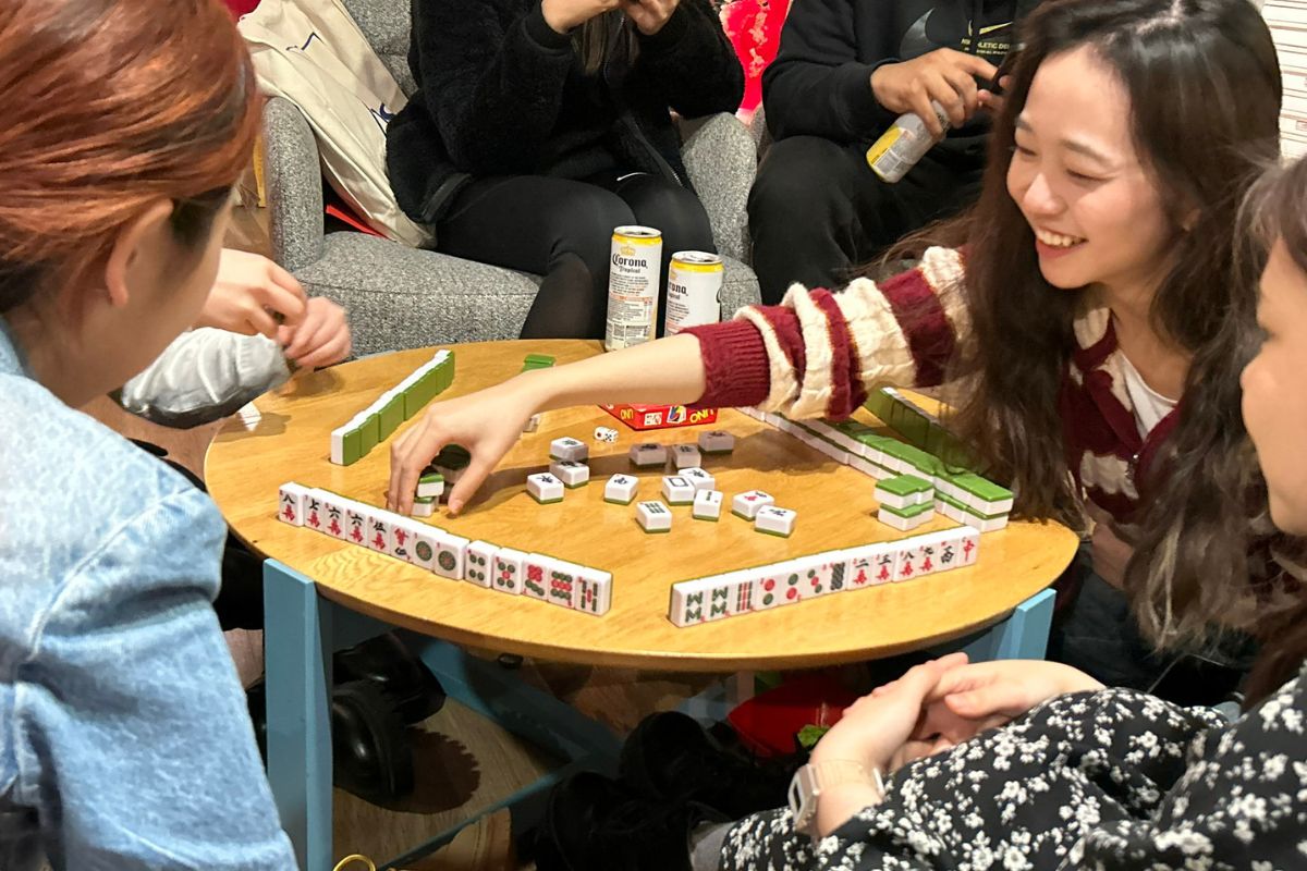Girl playing the board game Mahjong with friends