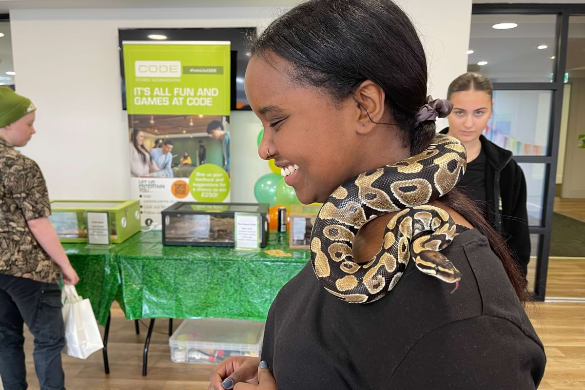 Student smiling with snake