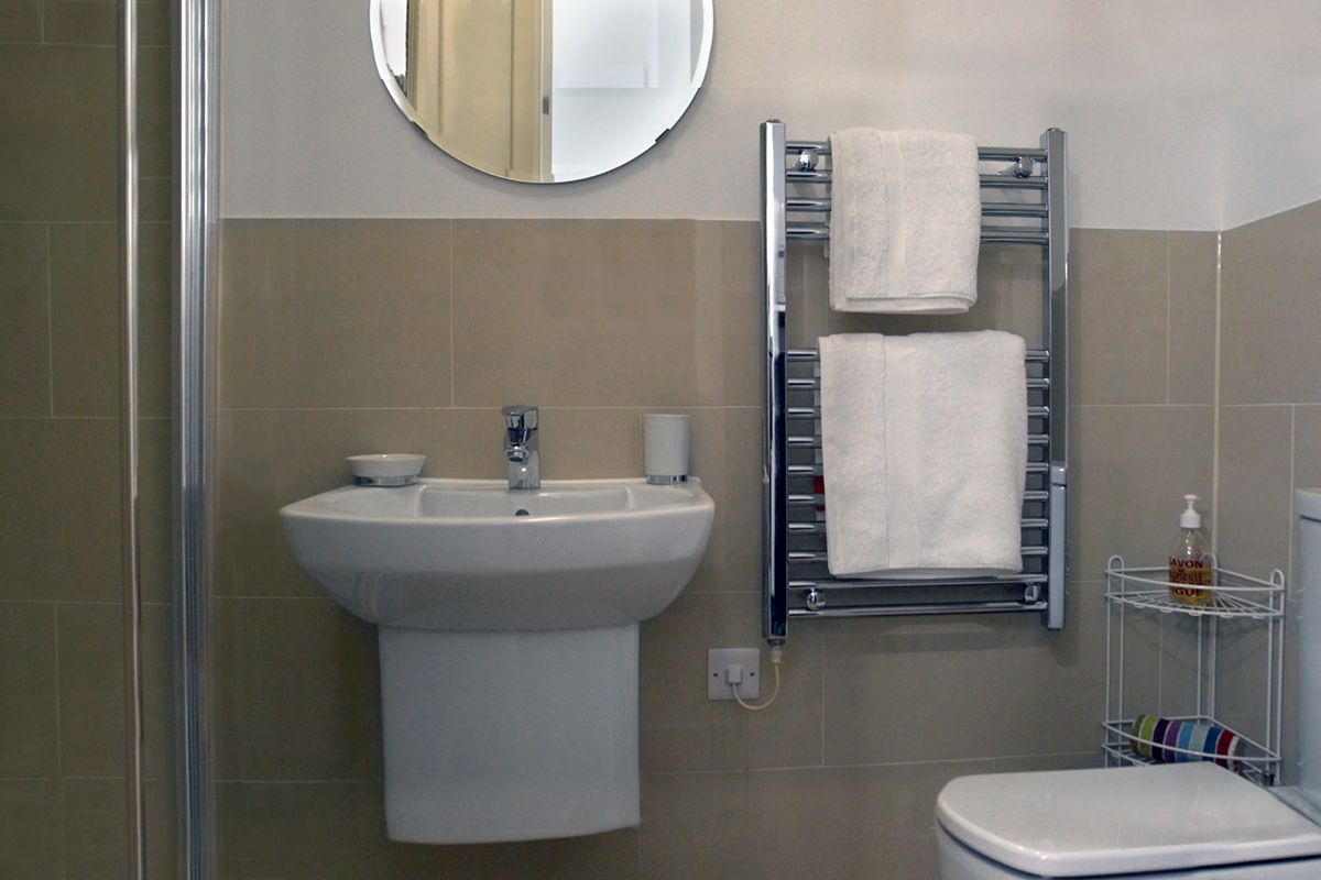 Bathroom featuring sink, towel rail, toilet and double shower