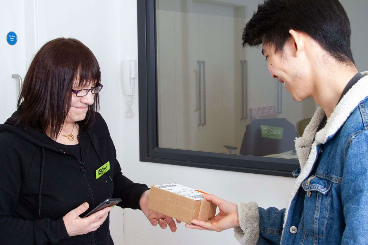 CODE staff member handing parcel to student