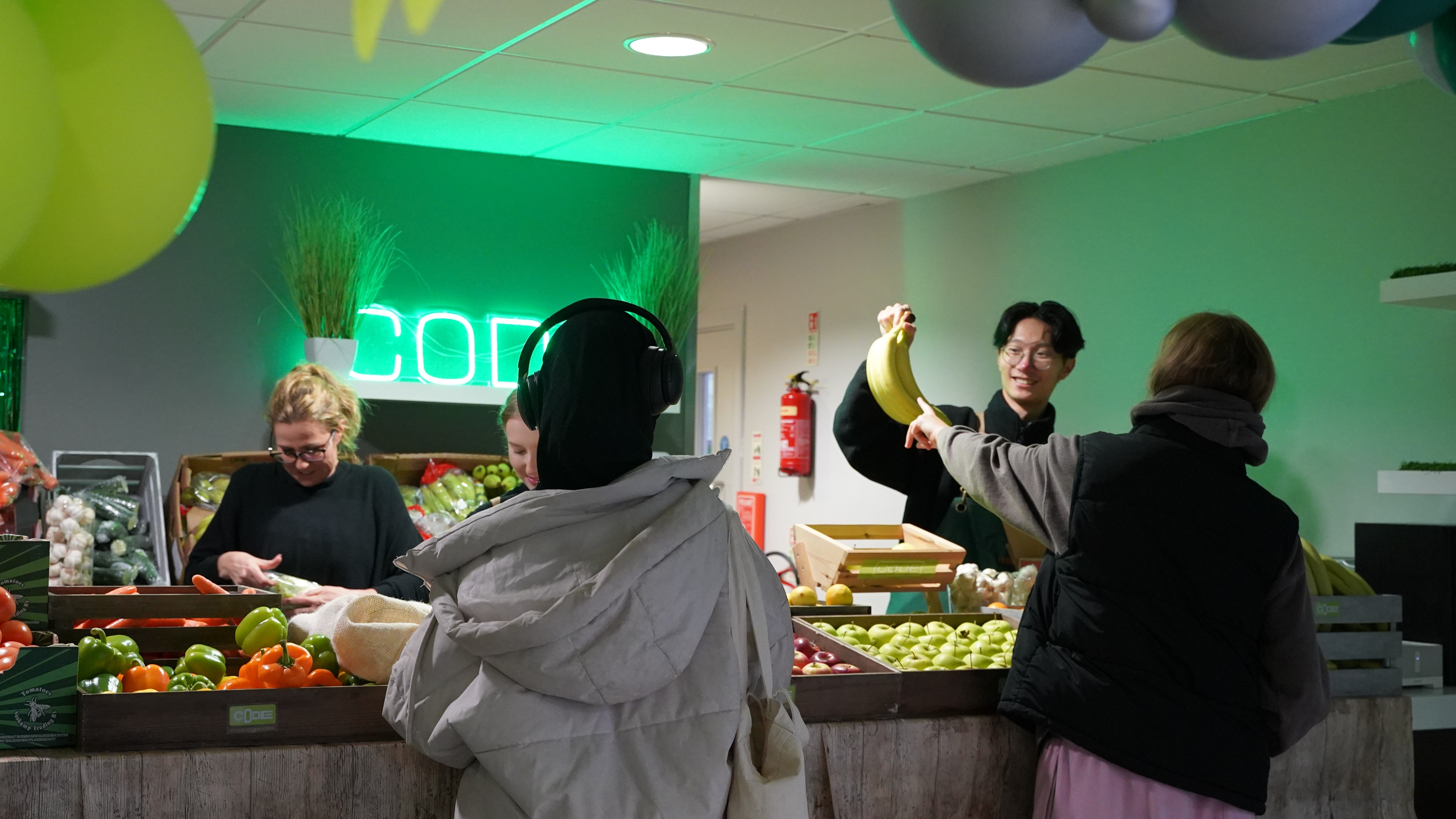 Student pointing at a bunch of bananas at the fruit and veg event