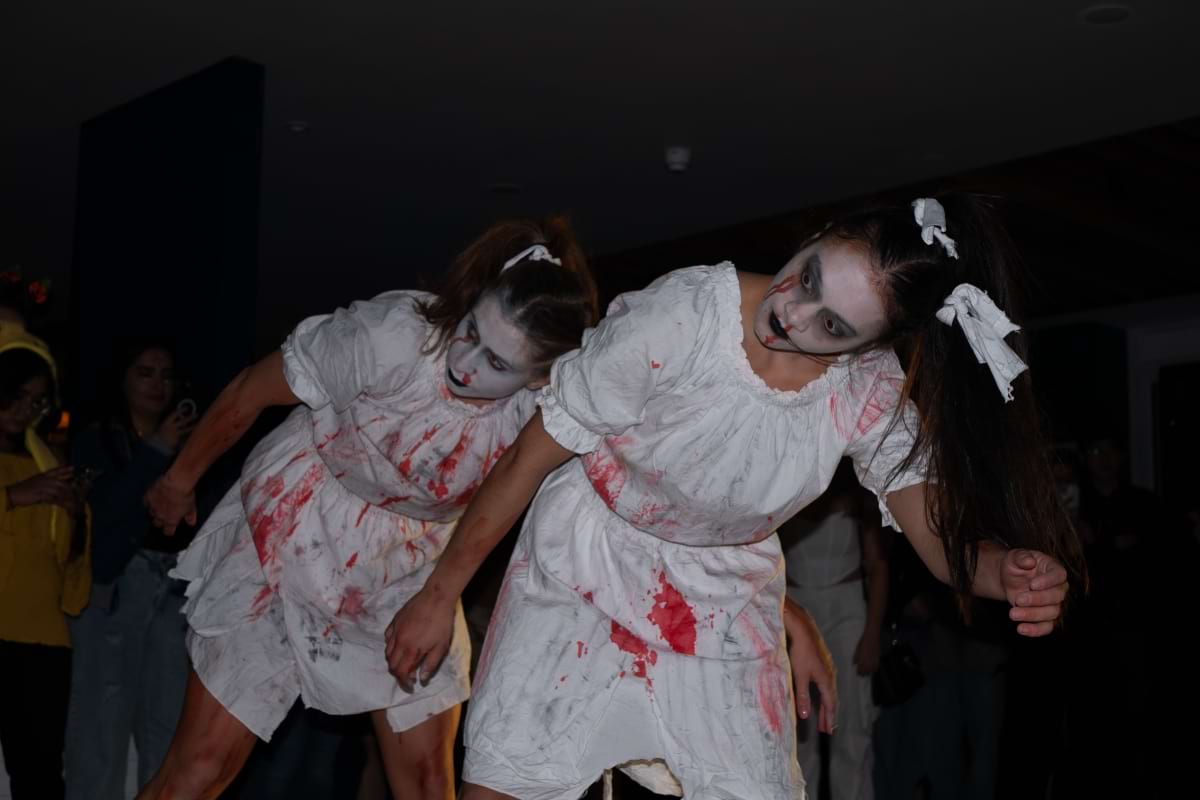 Two zombie dancers lean to the side creepily