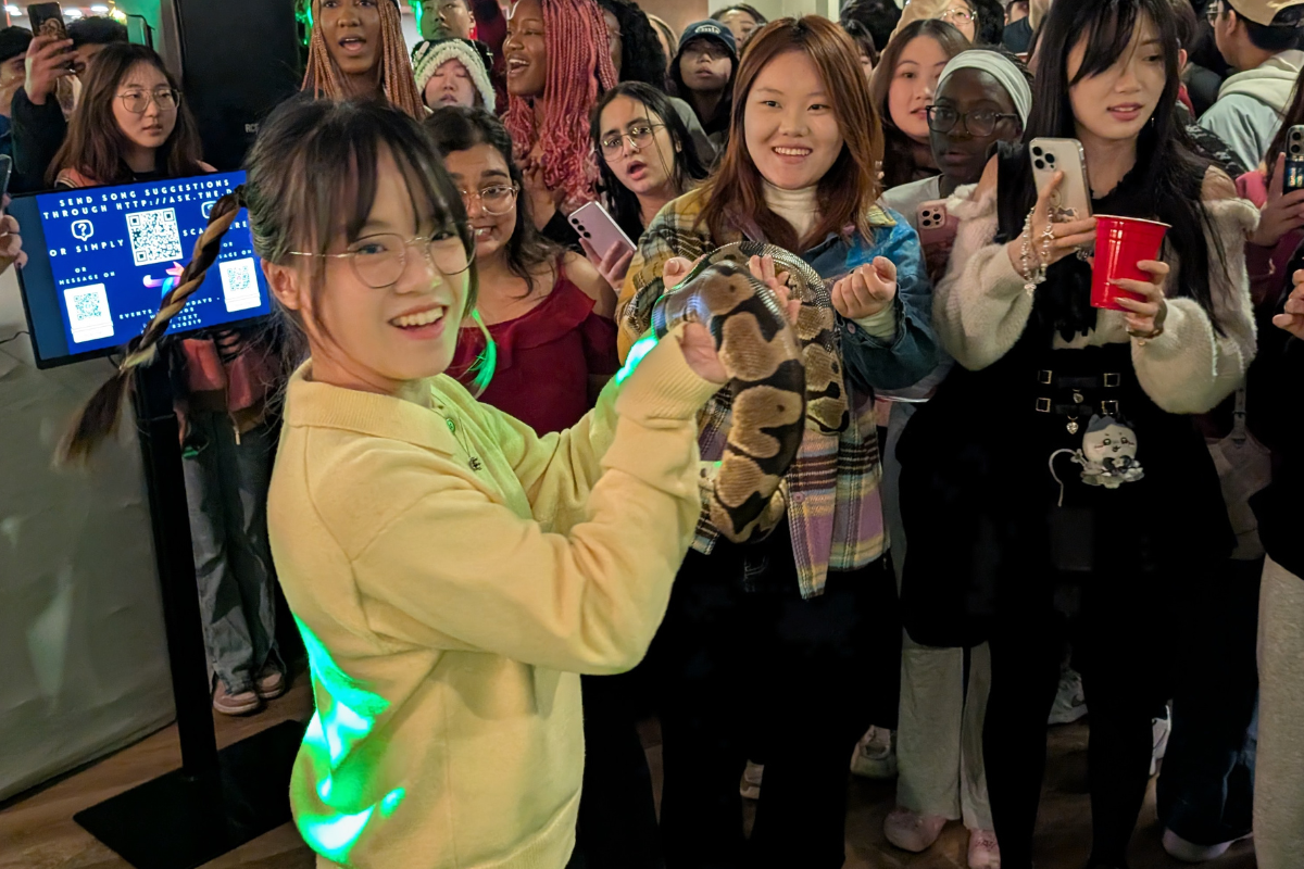 Student holds up snake to show crowd at Lunar Party