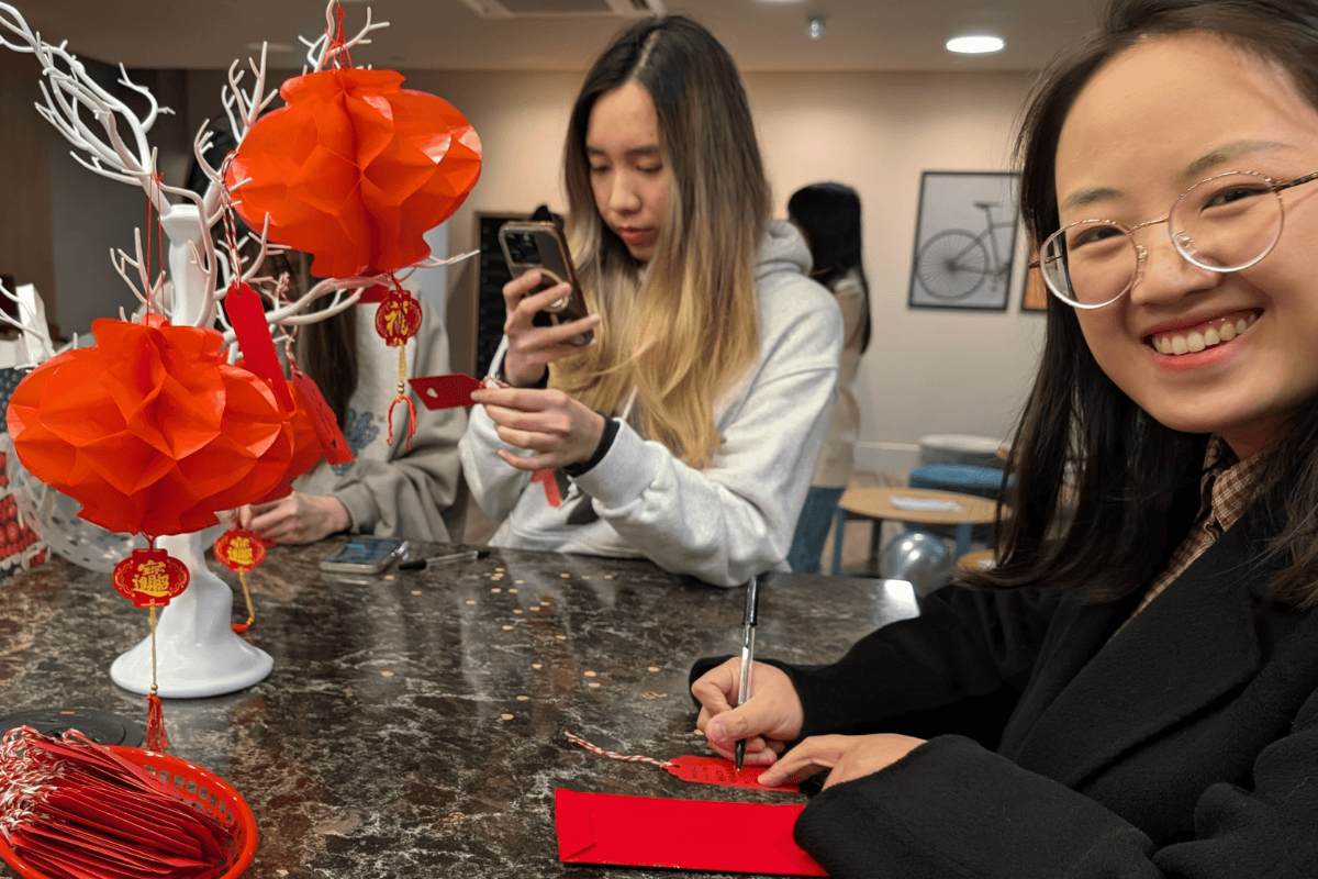 Student smiles whilst writing a wish for the New Lunar Year