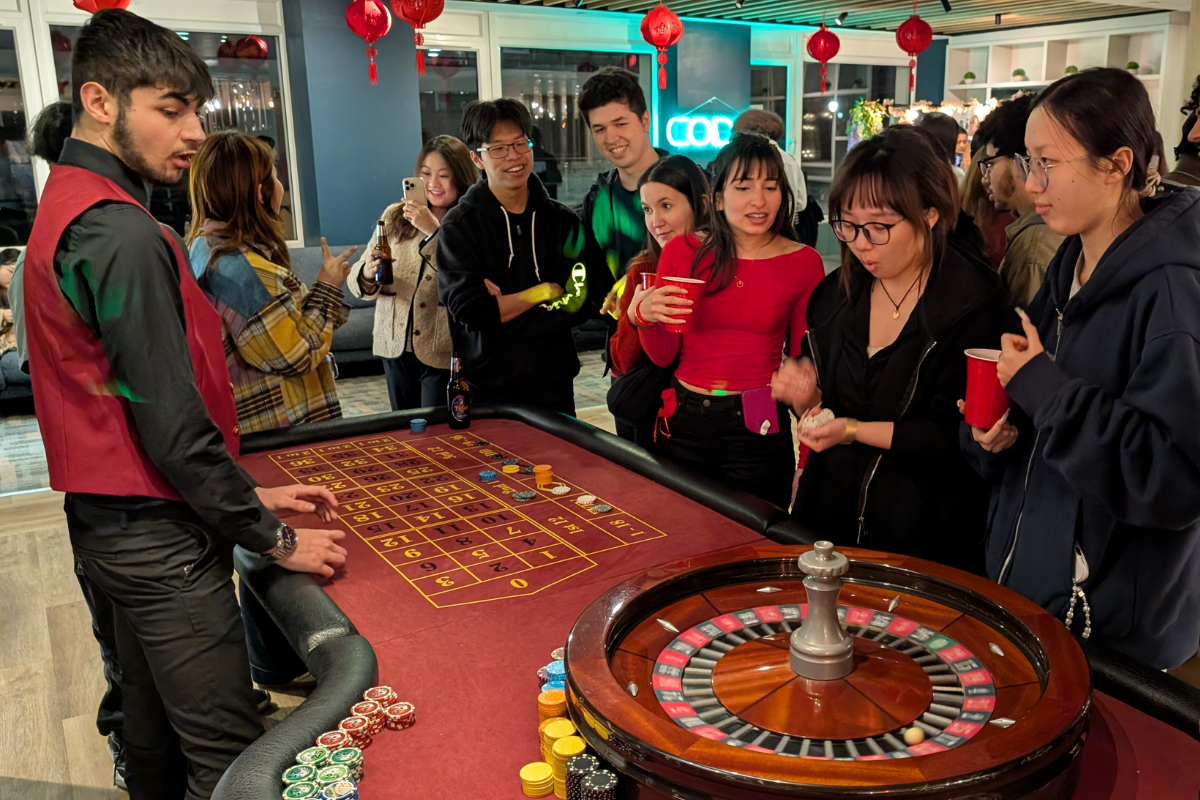 Students gather around a cash free casino table