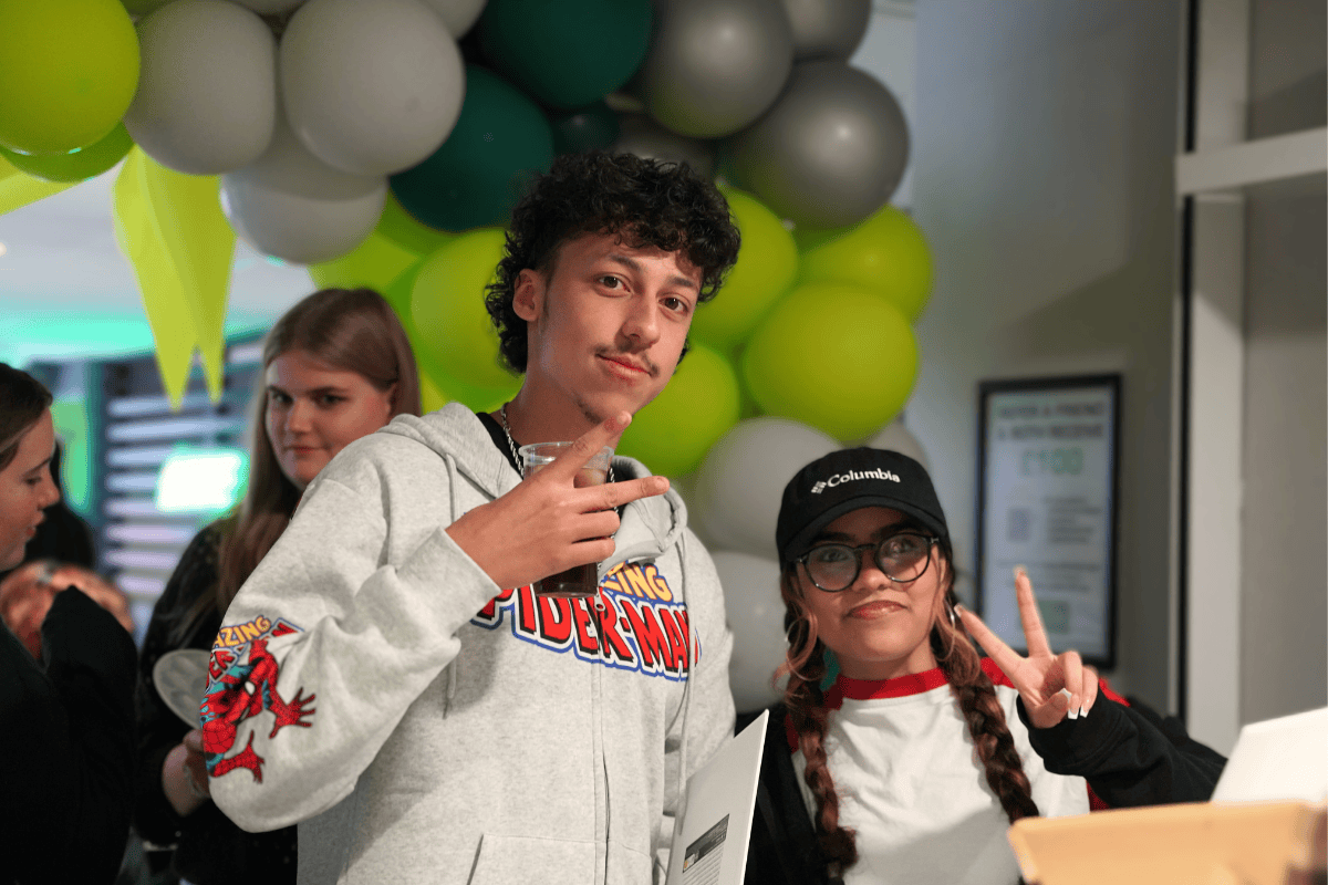 Two tenants at our sip and paint event holding up their hands showing the peace sign to the camera