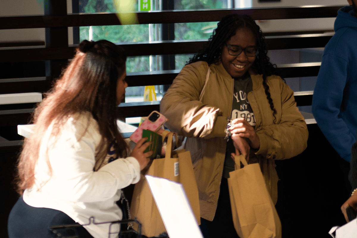 Two friends smiling together after picking up some free items at our event