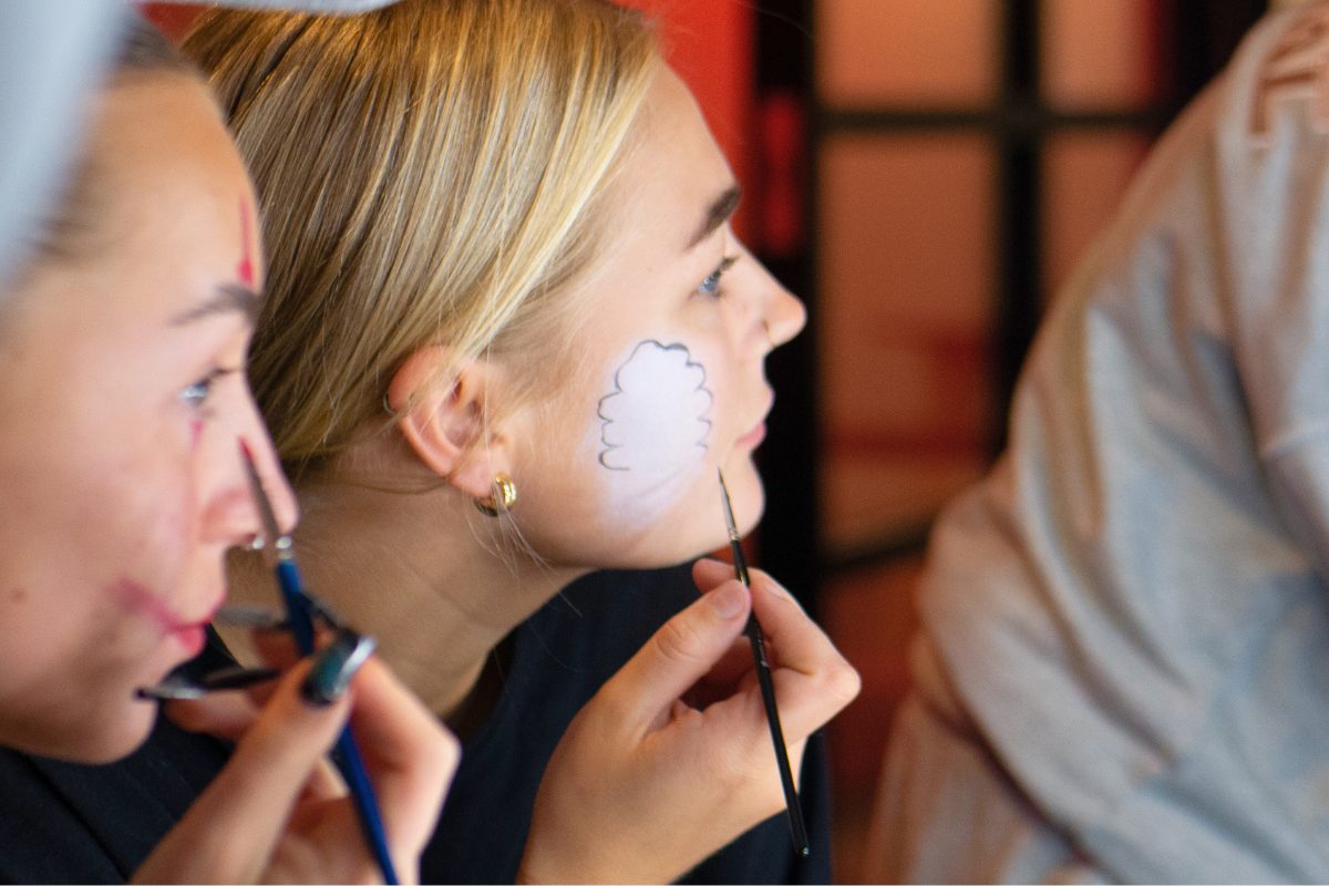 Two girls painting their faces for the Halloween Party