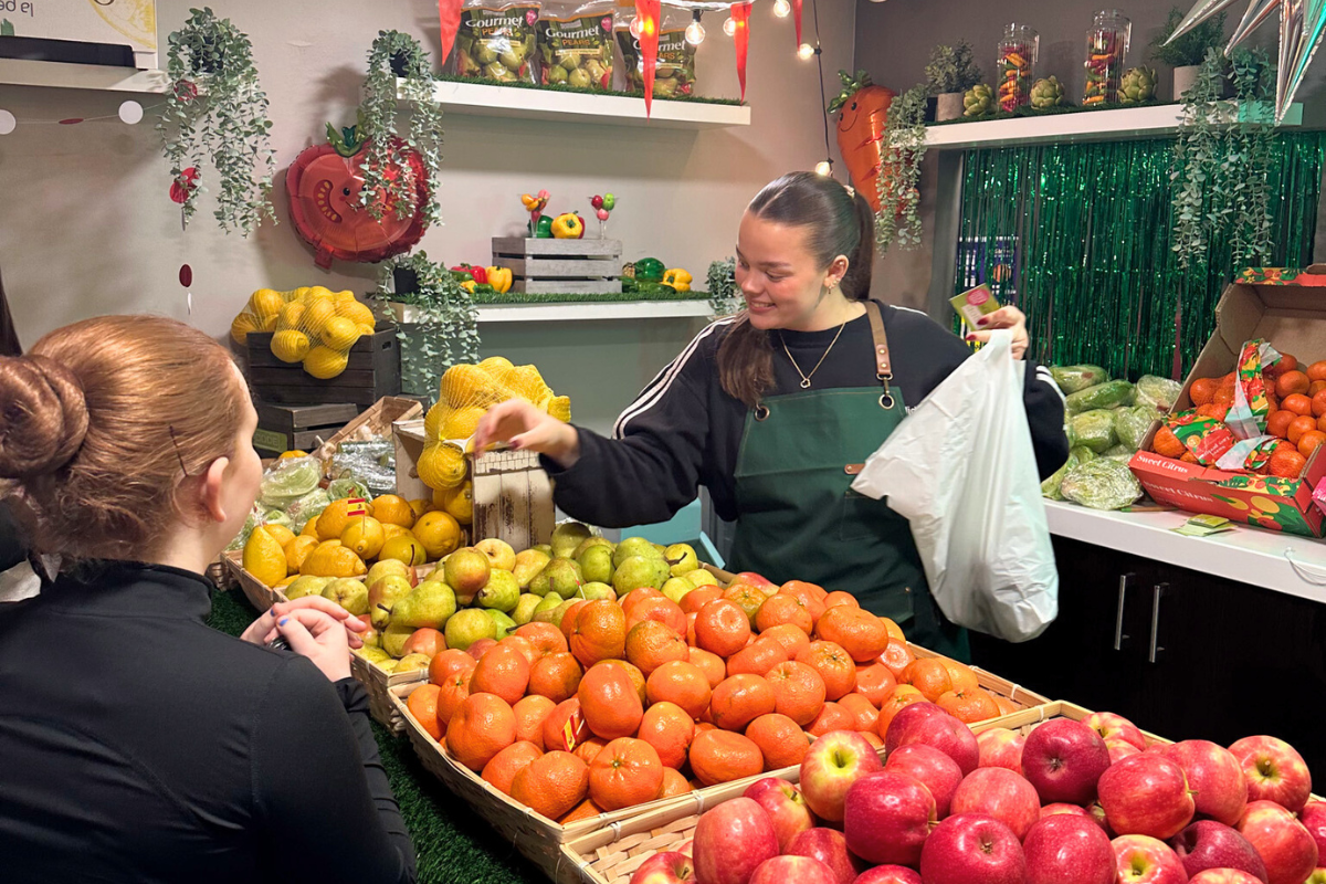 A Code team member giving out some free fruit and veg to one of our Code tenants