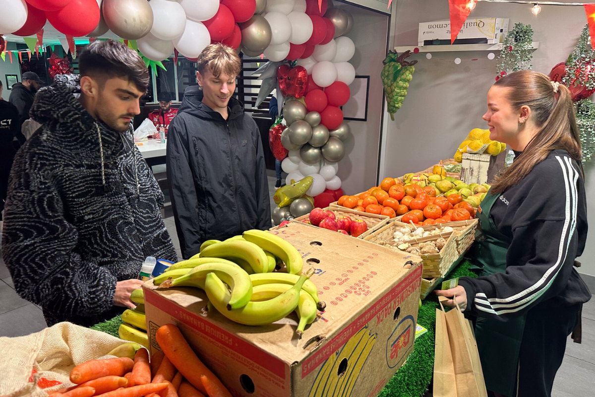 Two CODE tenants looking at our table of Fruit and Veg