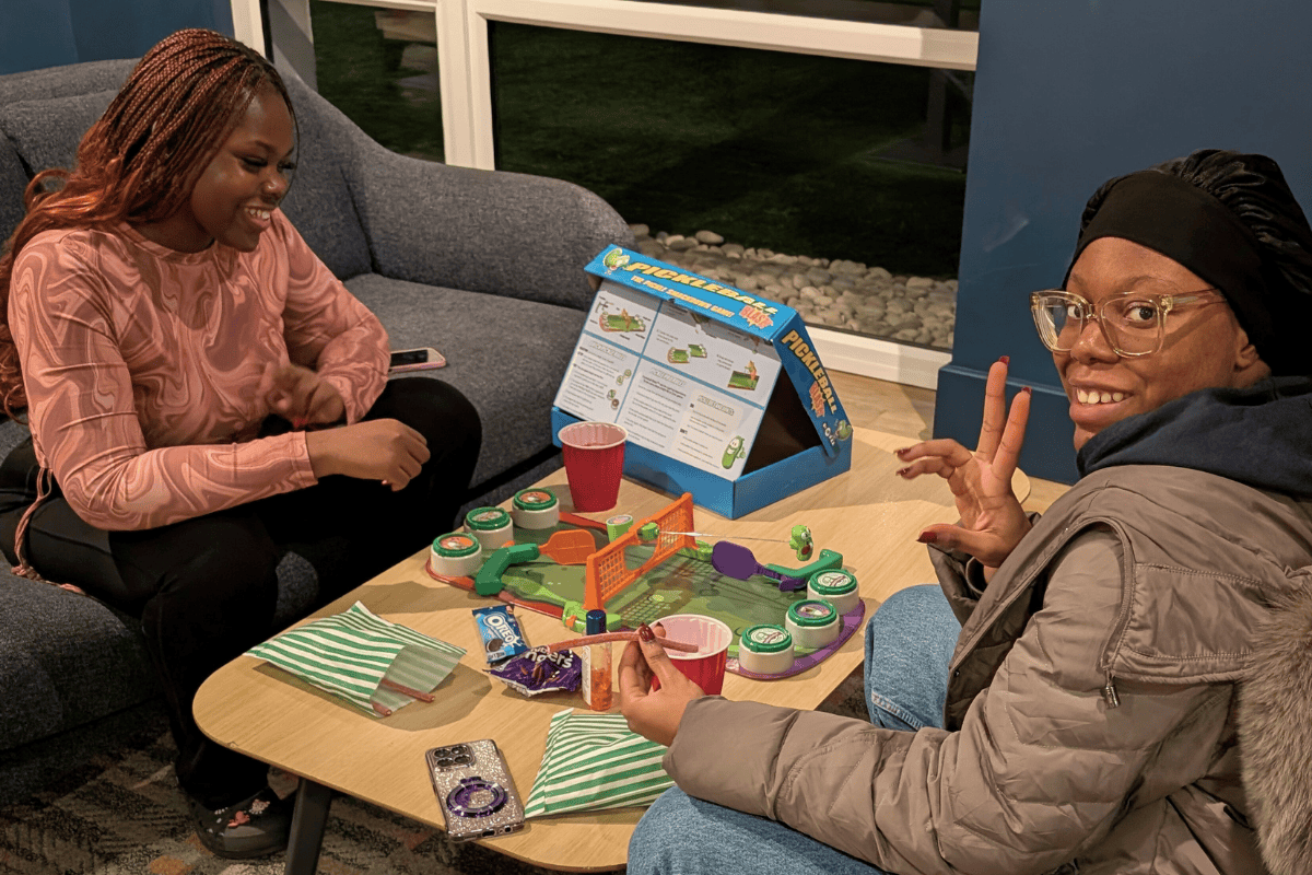 Two girls sitting at a table playing a pickle game