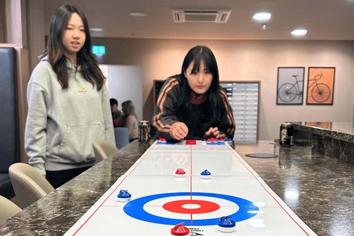 Two girls playing miniature curling looking very focused