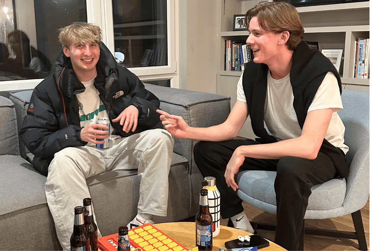 Two CODE tenants sitting down at a table playing some games and having a few drinks