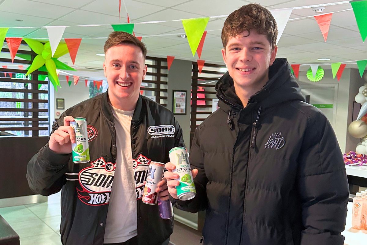 Two CODE tenants holding up energy drinks at the CODE event