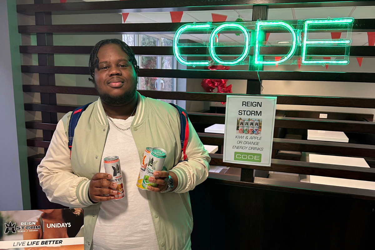 A guy posing with energy drinks in his hands