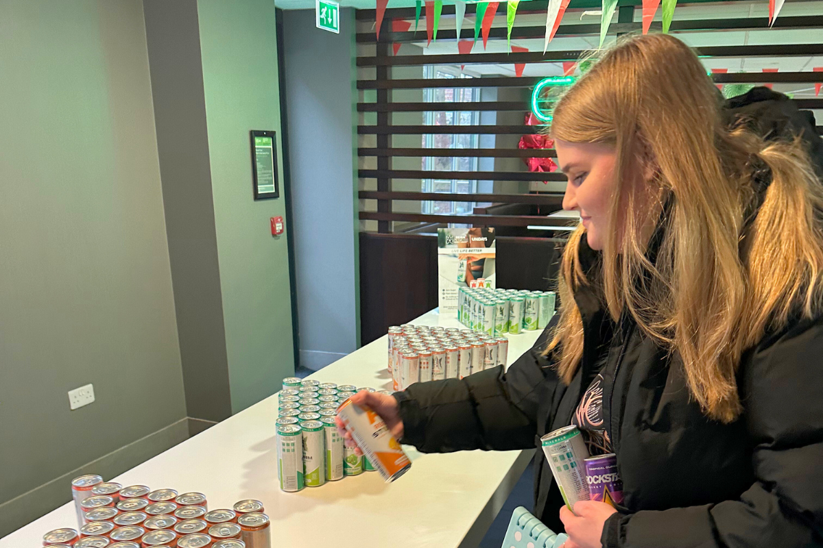 A girl grabbing a free energy drink at the CODE event