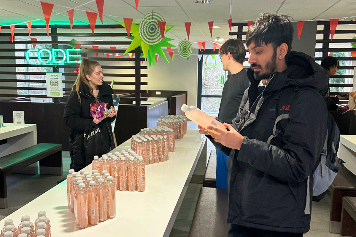 A table full of vitamin waters and tenants looking at the drinks at the CODE FREE energy drinks event