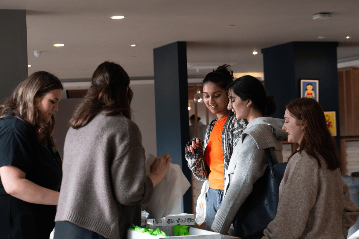 Students smiling as they queue for free pamper products