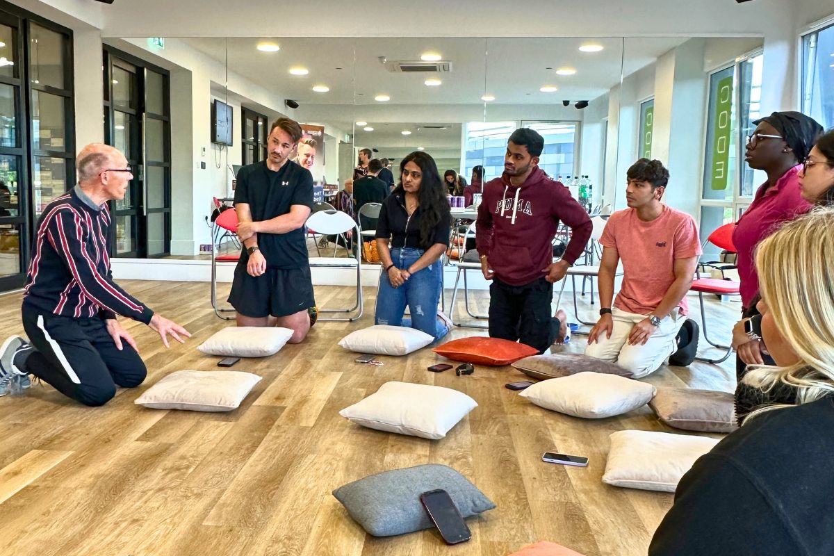 The instructor is showing the students how to do CPR