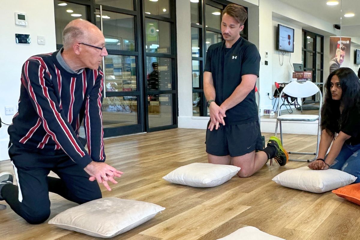 The instructor showing a student how to do CPR