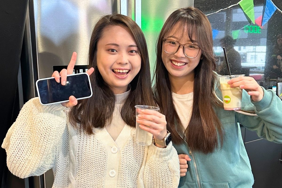 two students with their drinks at the easter crafting event