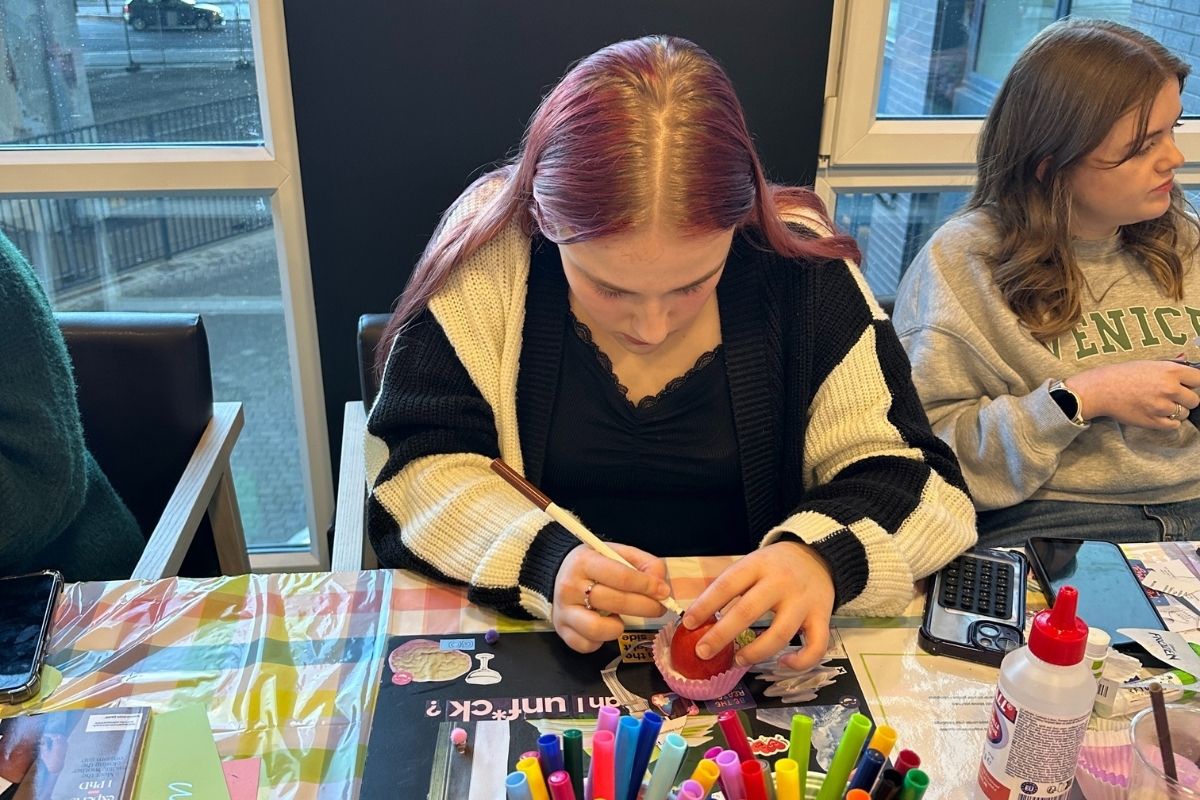 A concentrated student decorating an egg at the easter crafting event