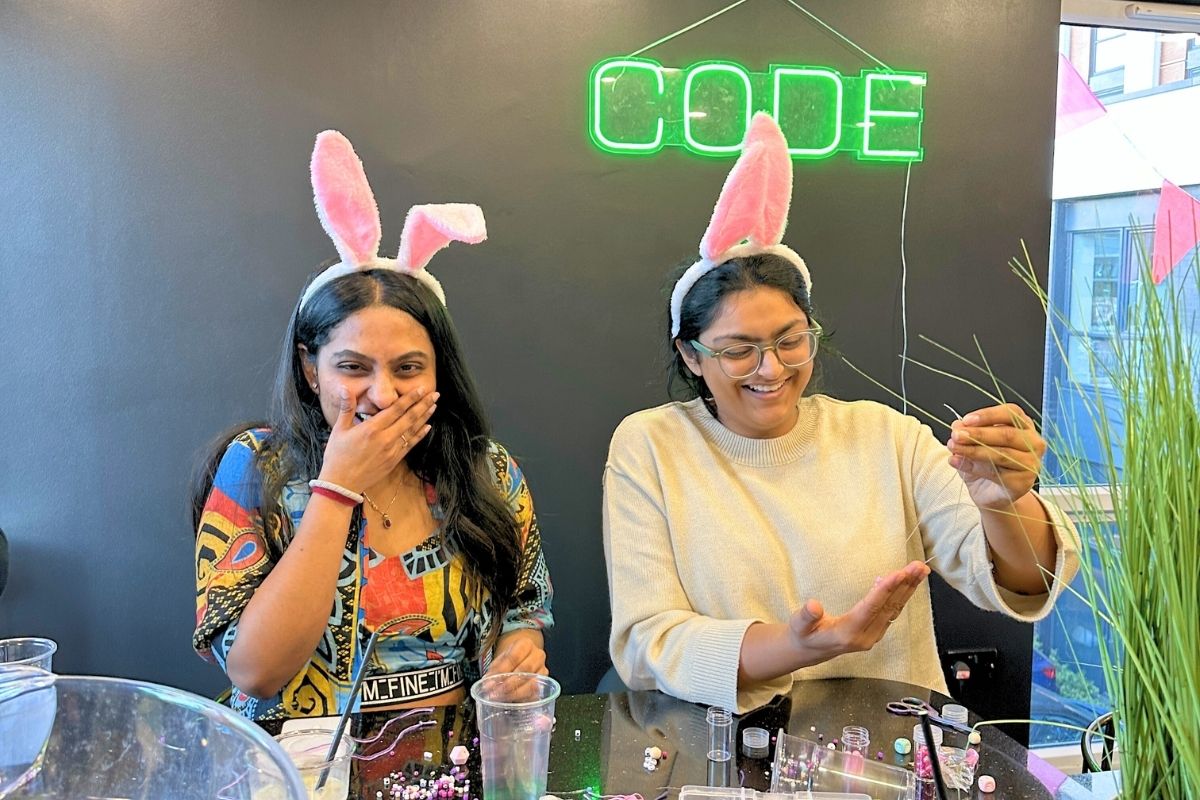 two girls laughing while making spring bracelets