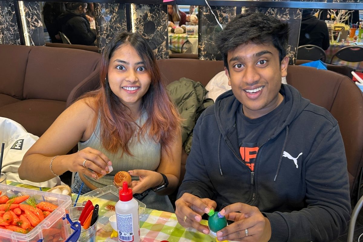 Two friends decorating eggs at the easter crafting event at code