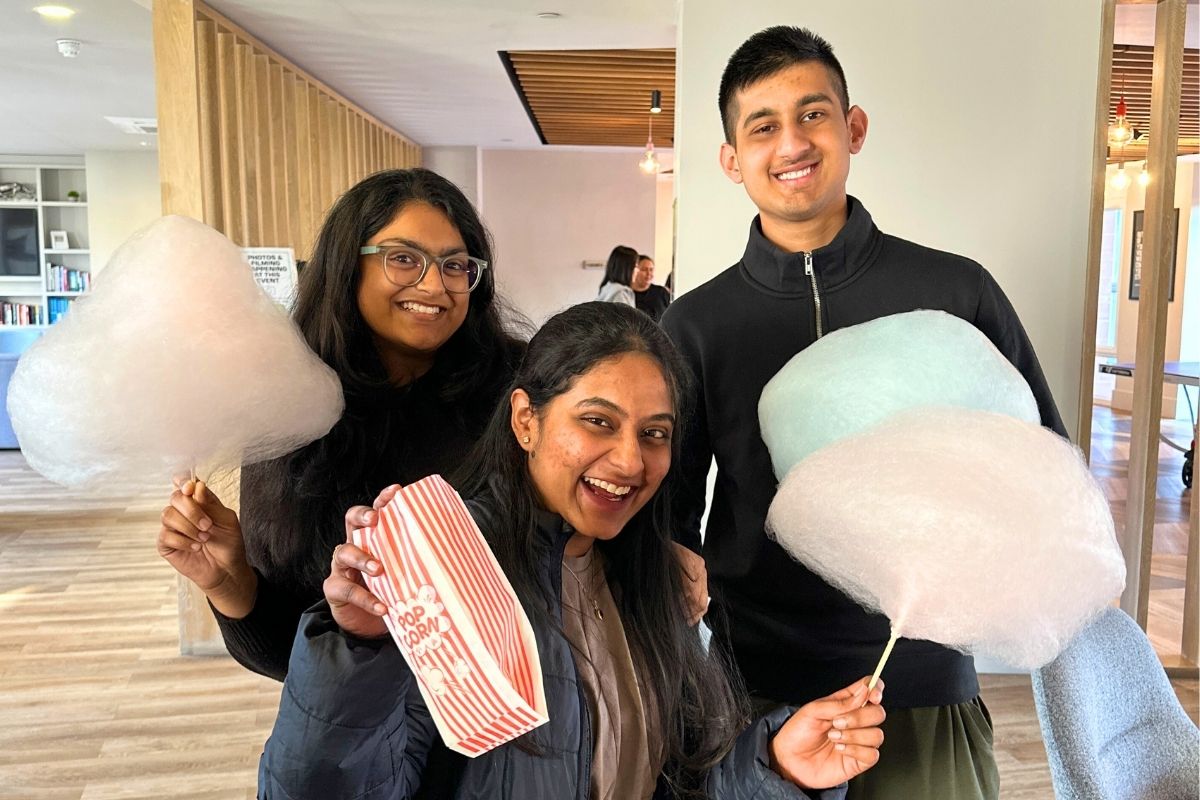 Three friends posing with their candy floss in the common areas where we held the CODE event