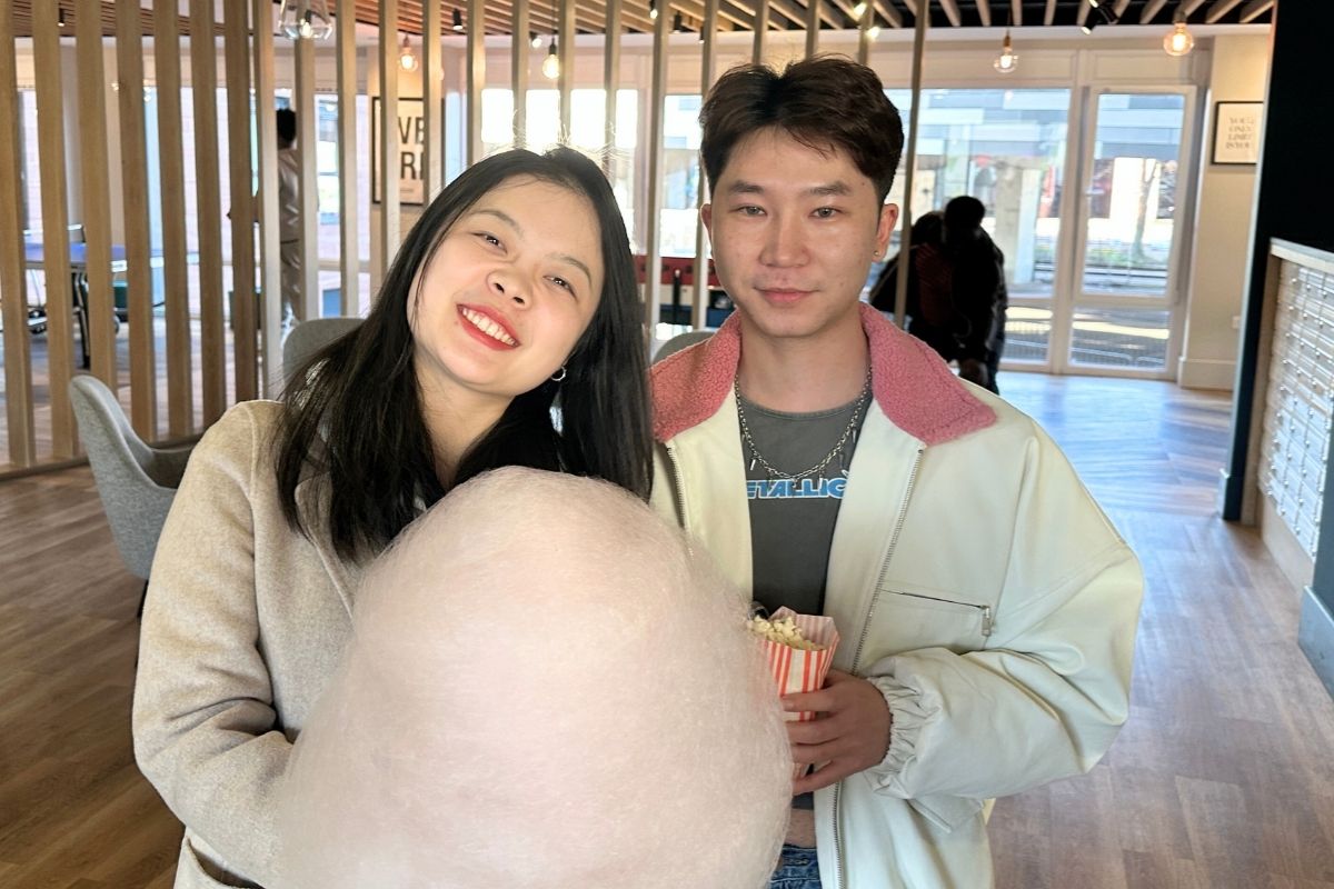 Two CODE tenants posing and sminilng with their popcorn and candy floss