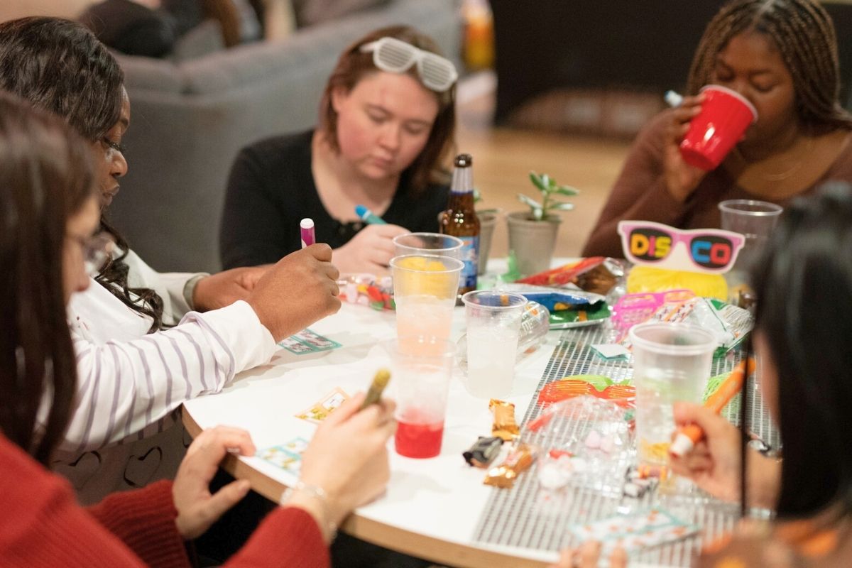 Code tenants around a table with drinks and bingo cards