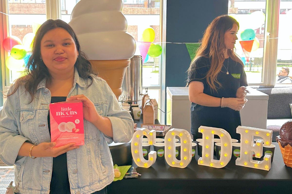 A CODE tenant posing in front of the CODE sign at the Little Moons Moochie Event 2025