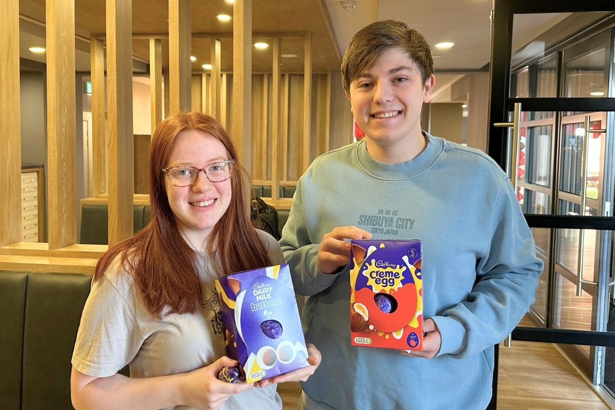 Two students holding their easter eggs that they found in the easter egg hunt
