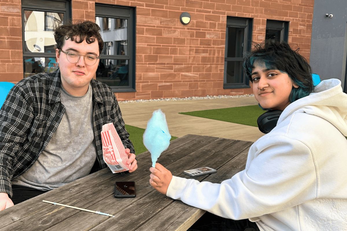 Two code students on the terrass enjoying their snacks