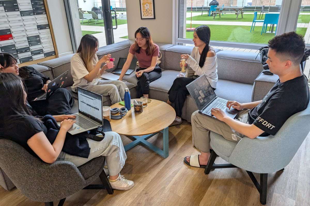 A group of students sitting together in the communal area while enjoying their ice creams