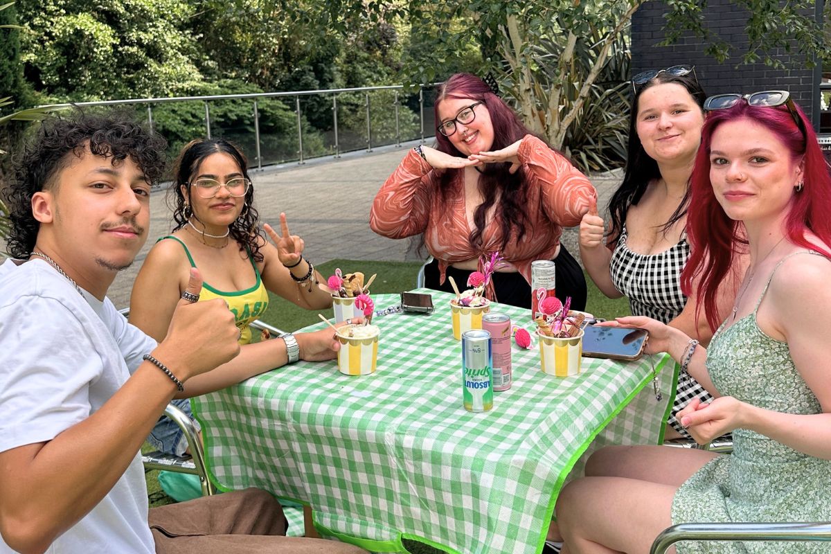 a group of students sitting at a table together enjoying their ice creams