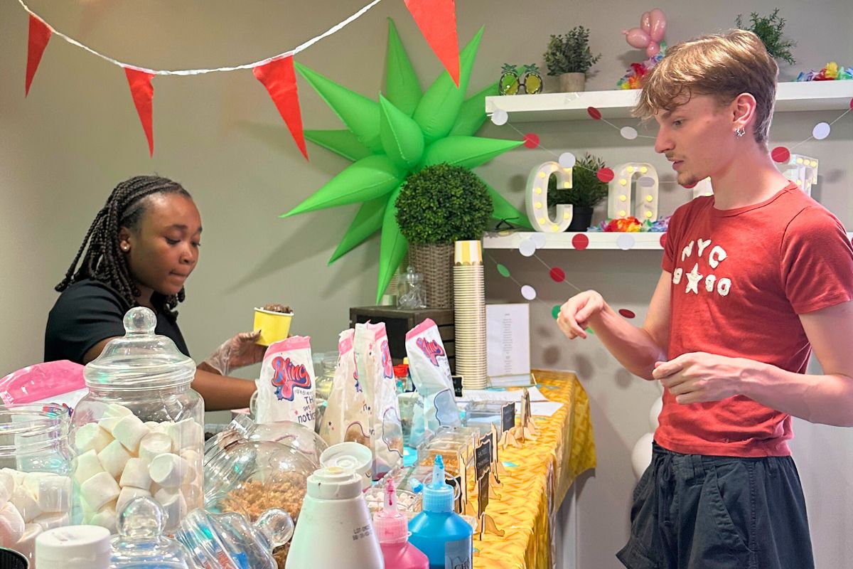 A tenant trying to decide what toppings to pick at the CODE ice cream event