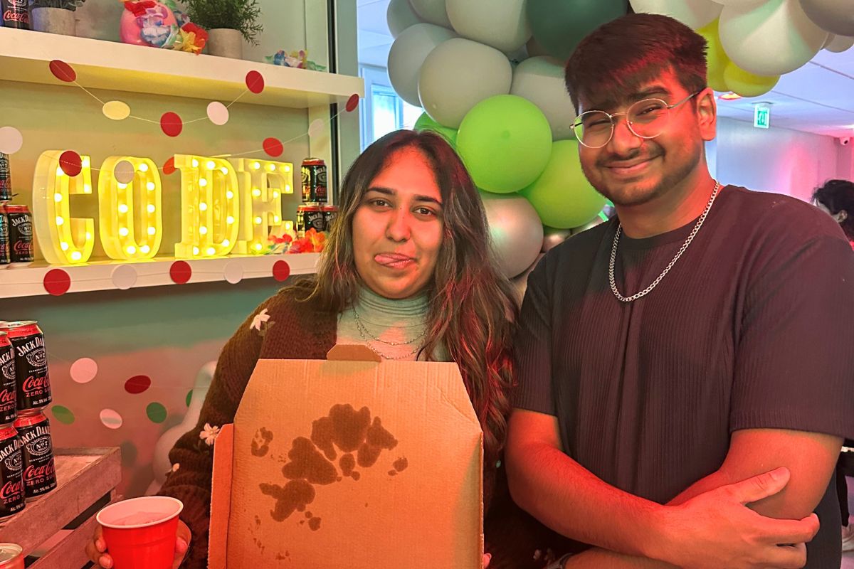 two students with a box of pizza