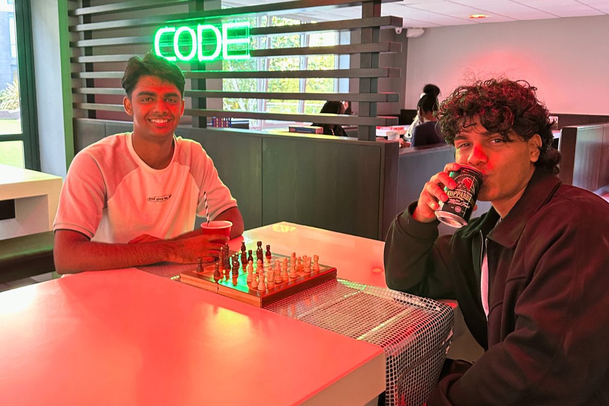 Two boys playing chess at the meet and greet