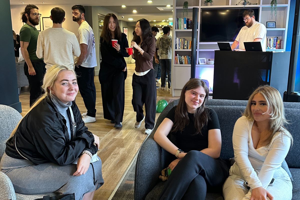 Friends hanging out next to the DJ at the CODE event