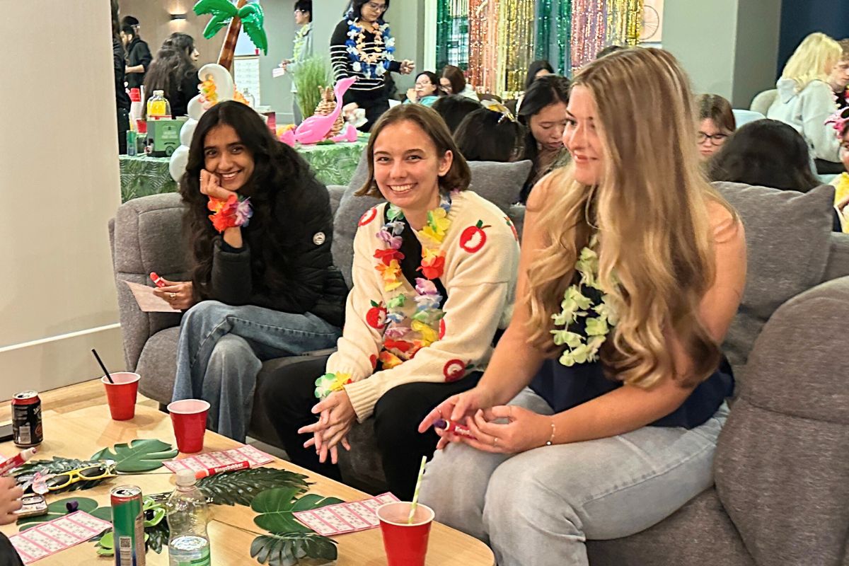Friends on a sofa playing bingo and enjoying drinks