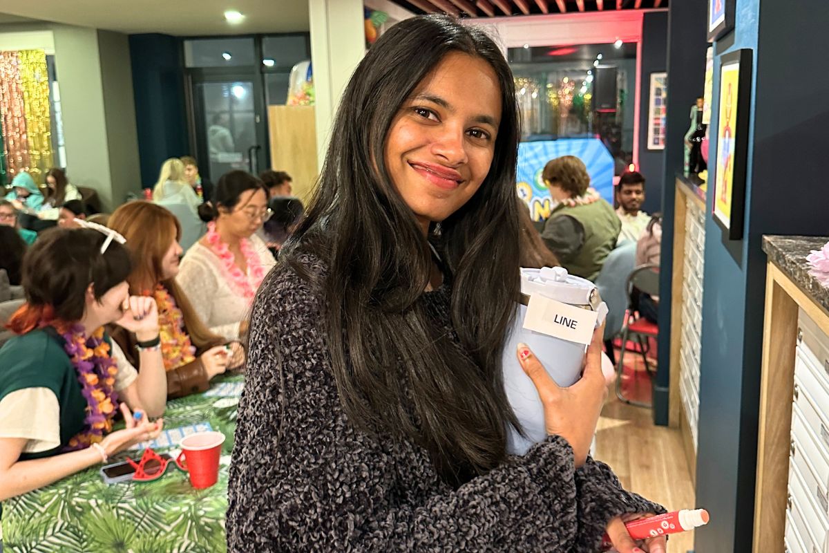 A tenant holding up their new water bottle they won at bingo