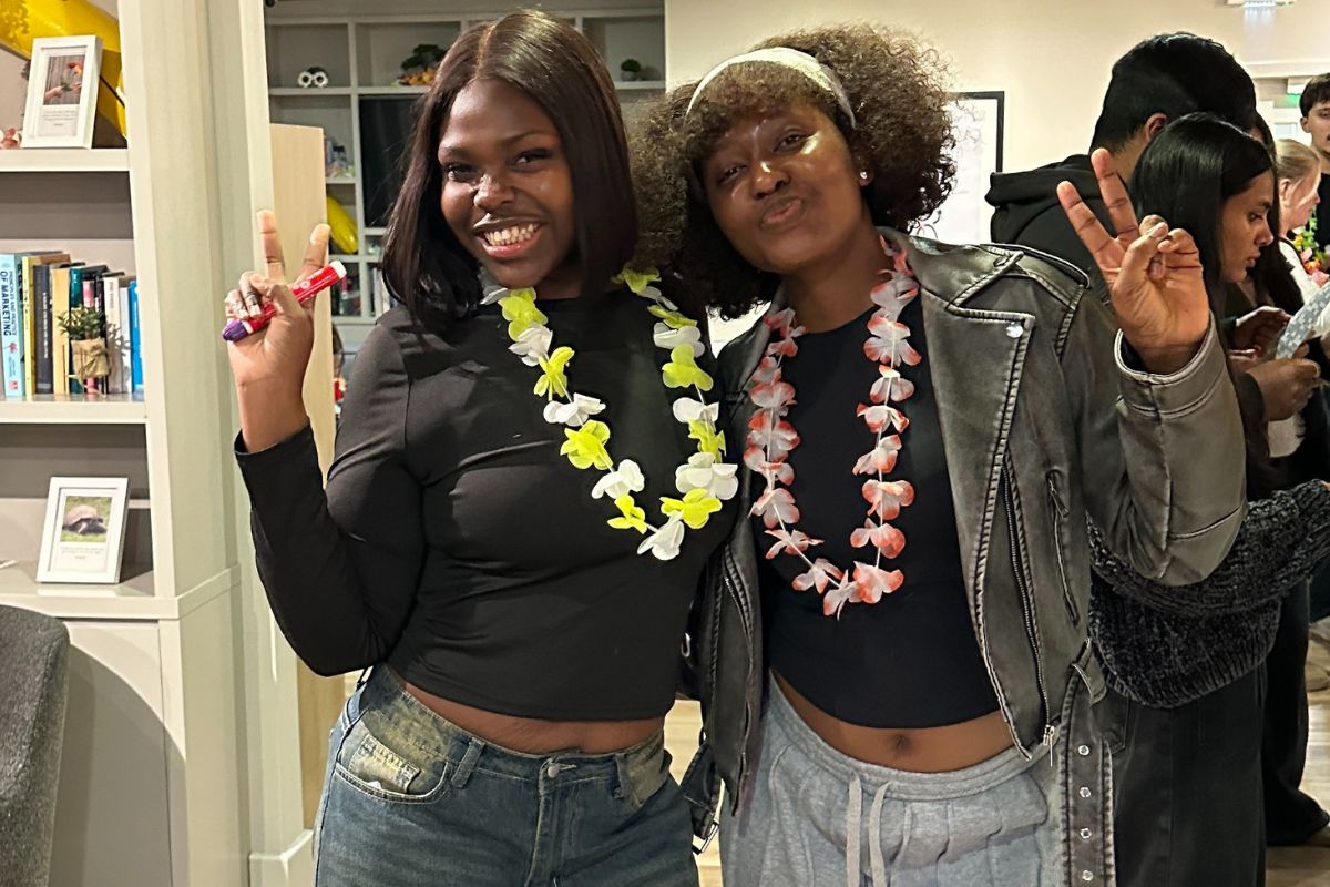 students holding up peace signs in front of the camera