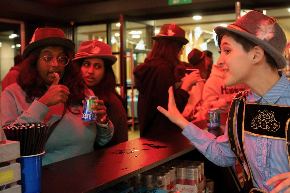 Students in Oktoberfest hats order a drink