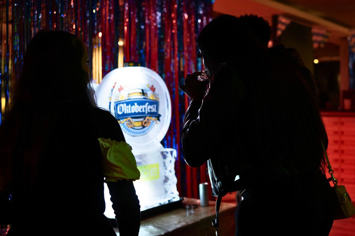 Tenants gather around the glowing Oktoberfest drinks ice sculpture