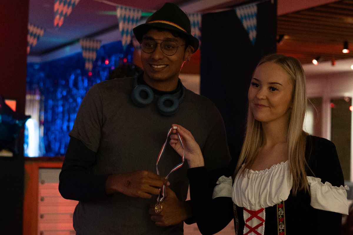 Two students proudly hold up a competition medallion